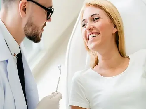 Young Dentist Talks With Patient In Dental Clinic.