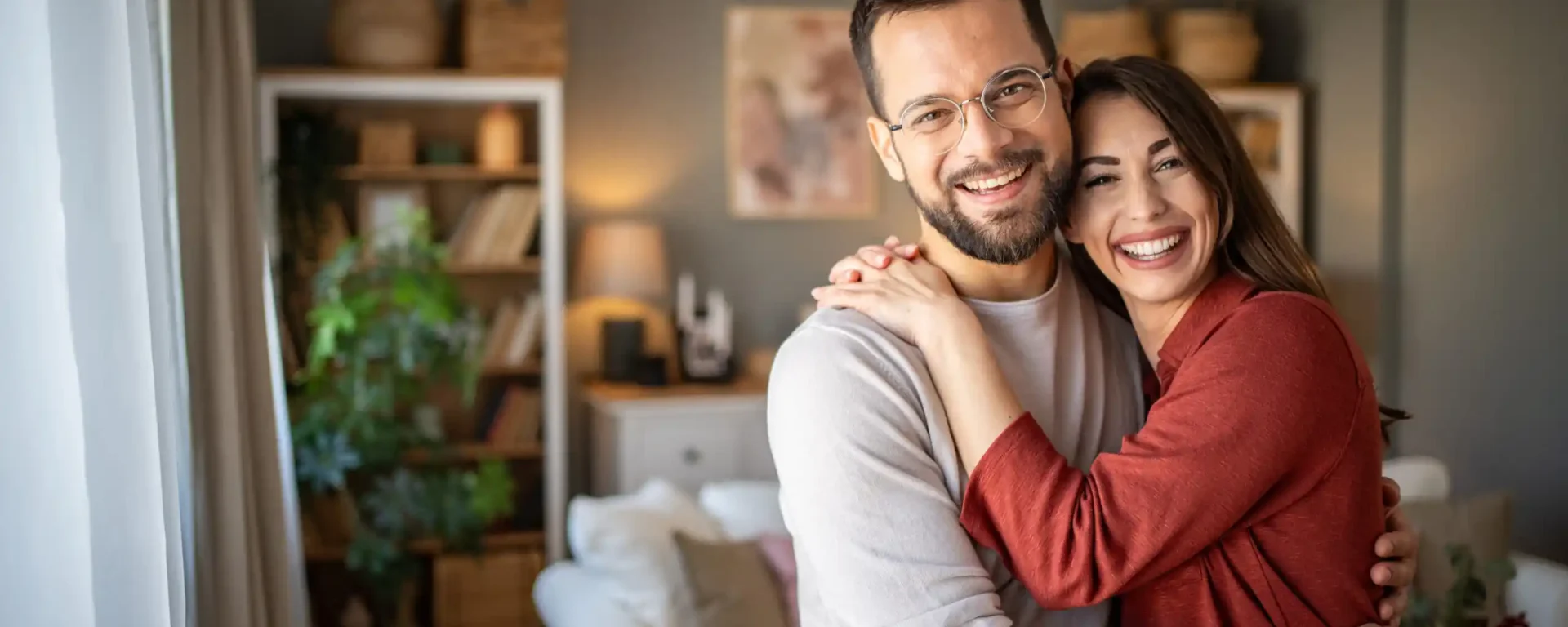 A wonderful scene of love and happiness between a couple in love standing embraced in their apartment
